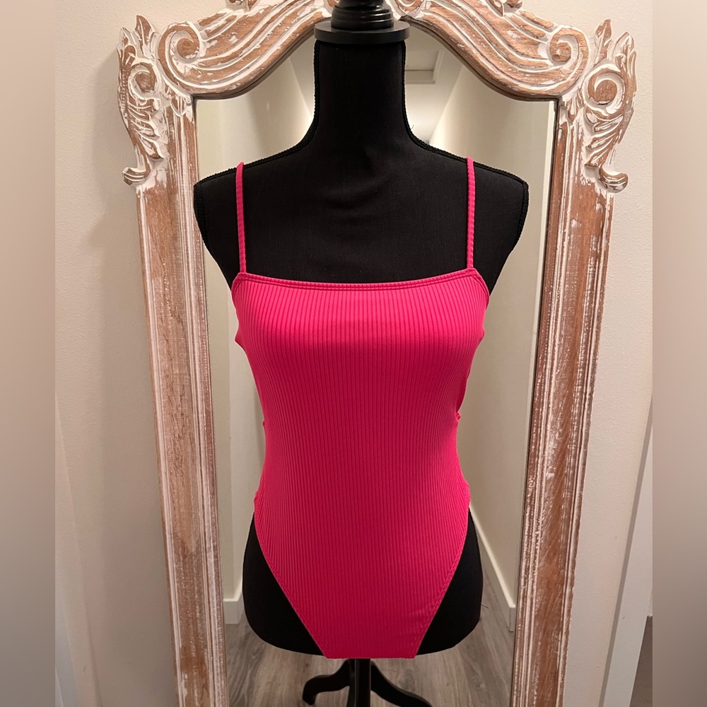 2 swim suits. One Black, one pink and a sun hat.